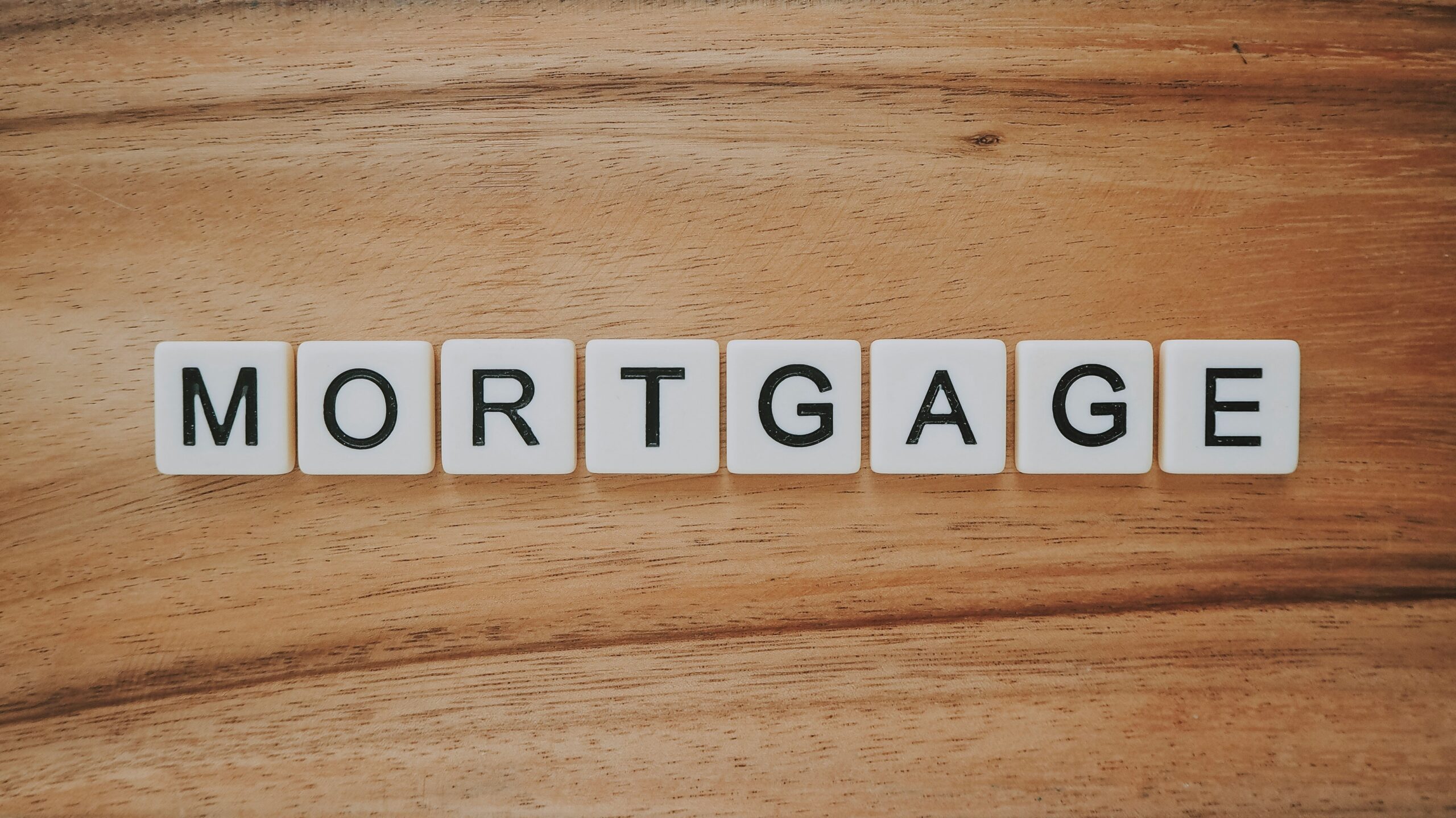Mortgage word with wooden background representing home financing